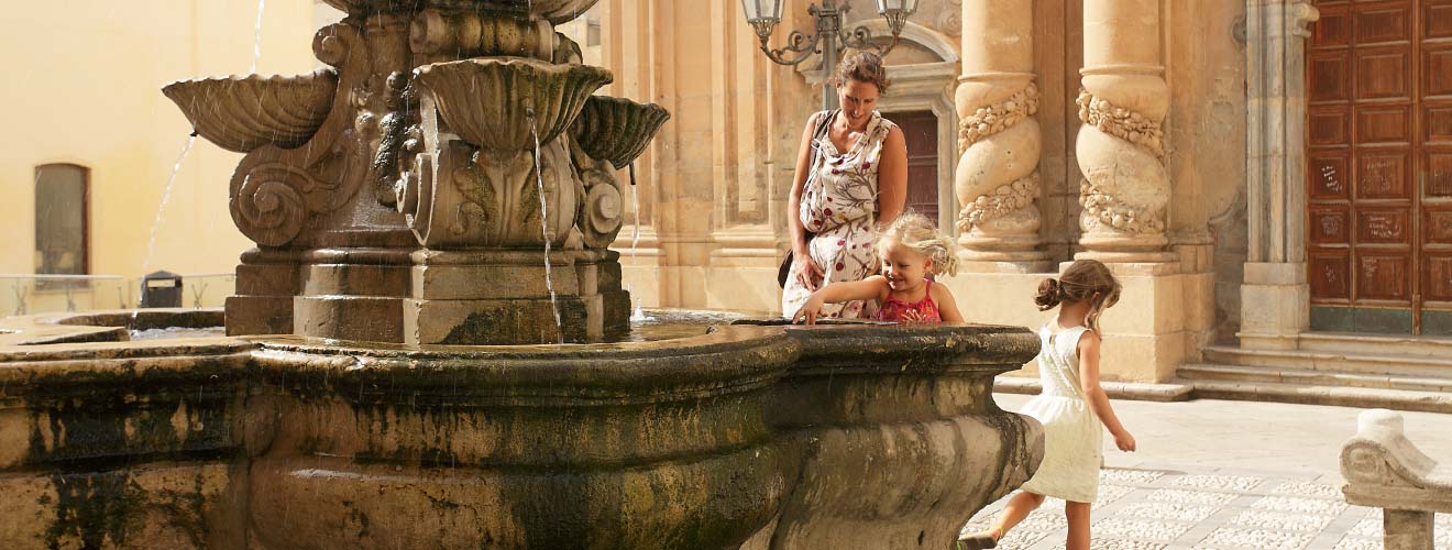 Famiglia vicino la fontana della Chiesa del Purgatorio a Marsala